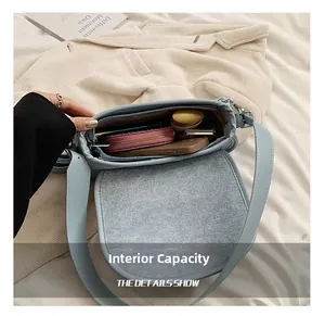 Internal capacity of light blue shoulder bag showing smartphone and cosmetics storage