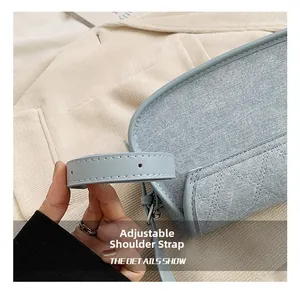 Detail of light blue quilted underarm bag with adjustable faux leather shoulder strap