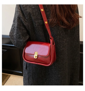 Detail of vintage red shoulder bag with gold twist lock and studs on high-quality leather