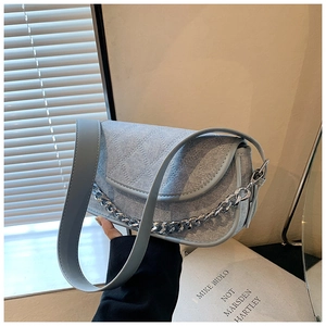 Detail of light blue denim hobo bag with quilted stitching and chunky silver chain