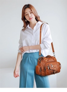 Detail of vintage brown soft leather tote with metal rivets and multiple pockets