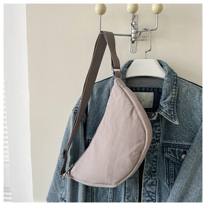 Detail of light purple crescent crossbody bag with adjustable wide fabric strap