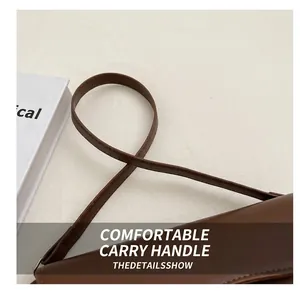 Detail of reinforced shoulder strap stitching on a vintage brown leather crossbody bag