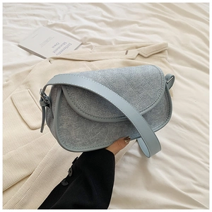 Close-up of light blue denim hobo bag featuring diamond quilted texture and faux leather strap