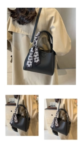 Dettaglio borsa in pelle nera con foulard a scacchi e logo del marchio goffrato