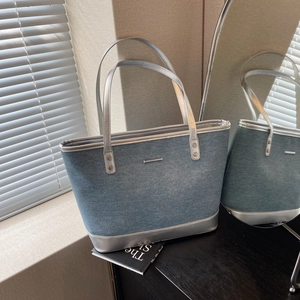 Large denim tote bag with silver metallic trim and handles for stylish daily commute