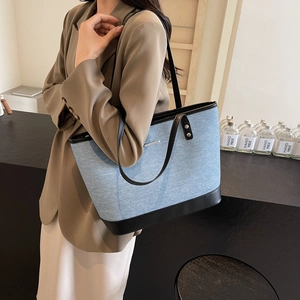 Large denim tote bag with black leather straps for women's stylish daily commute