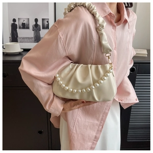 Detail of cream white pleated cloud bag with pearl chain and matching ruched strap
