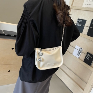 Sac bandoulière blanc crème chic avec chaîne en métal et pendentif boule argentée