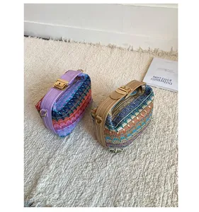 Detail of colorful woven handbags with faux leather straps and golden metal buckles
