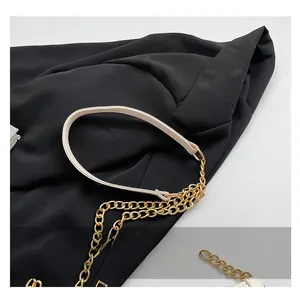 Detail of cream PU leather shoulder strap with light gold metal chain on a square bag