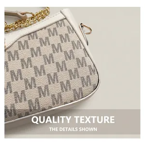 Close-up of white pebble leather bag with black M letter print and golden chain strap