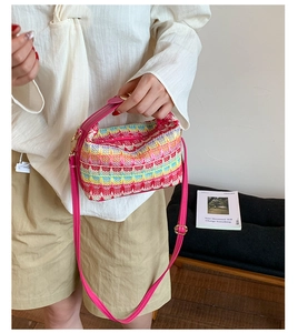 Detail of bohemian woven bucket bag with vibrant pink leather straps and colorful patterns
