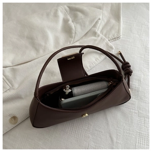 Interior view of the dark brown leather shoulder bag showing smartphone and lipstick
