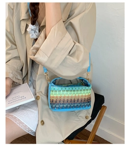 Dettaglio borsa a secchiello boho con trame geometriche e manico in pelle blu per la spiaggia