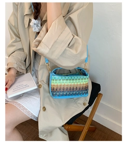Close-up of colorful woven mini bag with blue leather strap and geometric patterns