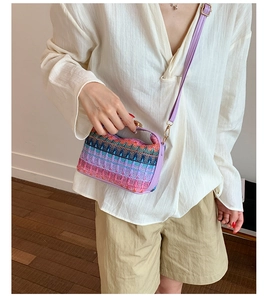 Detail of colorful woven bohemian bucket bag with purple leather trim and gold hardware