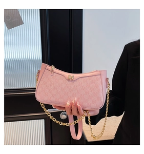 Detailed shot of pink faux leather bag with golden M emblem and chunky chain strap