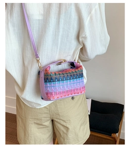 Detailed side view of bohemian knit bucket bag with colorful woven patterns and purple strap