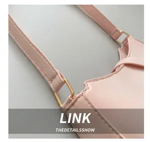 Detail of golden rectangular hardware buckle and neat stitching on pink leather shoulder bag