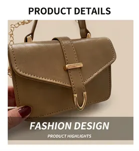 Close-up of brown faux leather flap bag with U-shaped metal buckle and gold chain strap