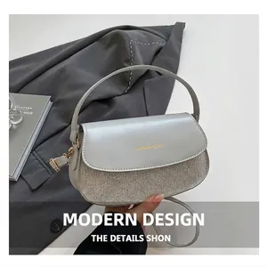 Detail of grey semi-circle bag with rhinestone panel and polished round top handle