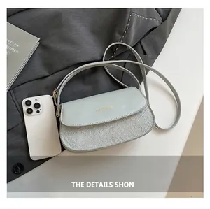 Detail of light green saddle bag showing woven texture and gold fashion lettering