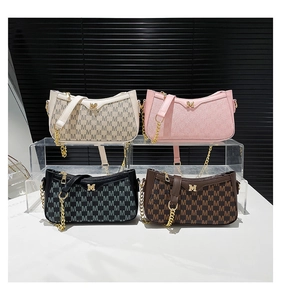 Detail view of stylish crescent underarm bags in cream, pink, black and brown colors