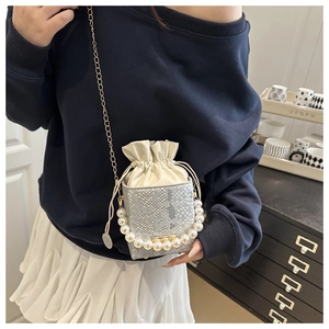 Detail of snake skin texture bucket bag with large pearl handle and gold chain