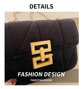 Detailed view of black velvet quilted shoulder bag with golden metallic square lock