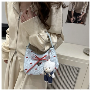 Close-up of light blue bag with red bow embroidery and a cute white bear keychain