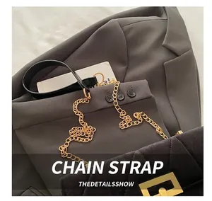 Detail of black quilted velvet crossbody bag with golden metal chain strap and lock