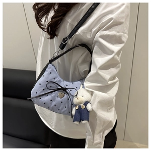 Detail view of striped bow shoulder bag with heart prints and a cute bear plush pendant