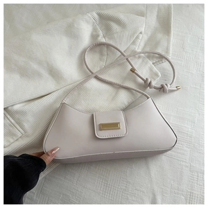 Detail of white baguette bag showing smooth leather texture and gold rectangular buckle