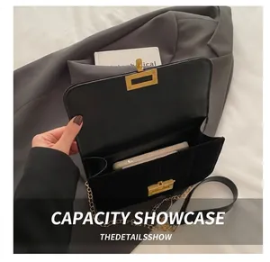 Close-up of black quilted chain bag showing interior capacity with a smartphone