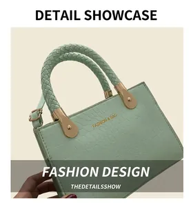 Detail of mint green crocodile pattern bag with woven handle and gold fashion lettering