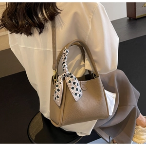 Borsa a secchiello marrone vista laterale con trama in pelle e foulard a scacchi