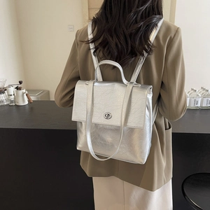 Sac à dos en cuir métallisé argenté avec poignée supérieure et fermoir rotatif pour femme