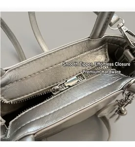 Macro shot of the smooth silver metallic zipper and crinkled leather texture