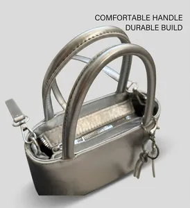Detail of silver metallic bucket bag showing round handles and smooth zipper closure