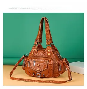 Detail of vintage brown washed leather tote bag with multi-pockets and metal rivets