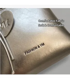 Detail of metallic silver bucket bag with soft grain texture and heart-shaped charm