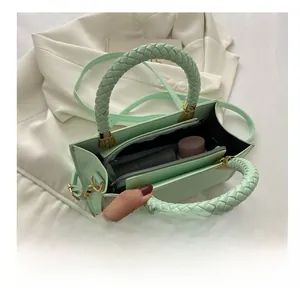 Interior view of crocodile-embossed green handbag with woven handle and zippered pocket