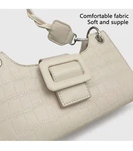 Detail of off-white baguette bag featuring crocodile pattern leather and large square buckle