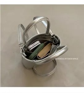 Top view of a silver metallic mini tote bag showing inner storage for phone and makeup