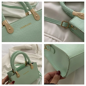 Detail view of mint green crocodile pattern PU leather bag with woven handle and gold hardware
