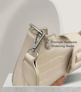 Detailed macro view of silver metallic spring buckle and creamy white crocodile texture bag