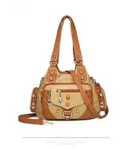 Detail view of khaki washed leather tote featuring vintage rivets and multi-pocket design