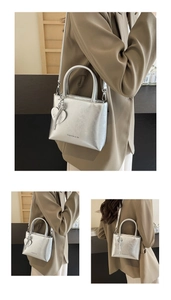 Close-up of metallic silver bucket bag featuring crinkled texture and heart charm