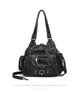 Detailed view of black washed leather tote bag with multi-pocket design and rivet details